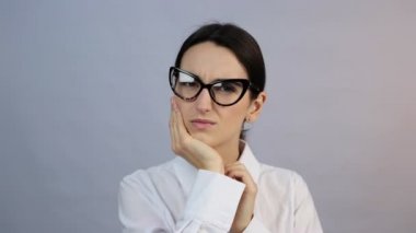 Diş ağrısı. Acı çeken genç bir kadın. Elleriyle yanağını tutuyor. Kötü diş ağrısı çekiyor.