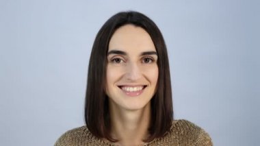 Kız kameraya mutlu bir şekilde gülümsüyor. Portre yakın çekim