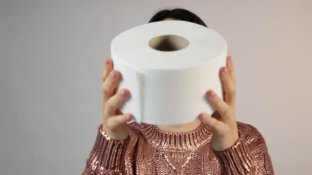 Uśmiechnięta dziewczyna prezentuje duży biały rolka papieru toaletowego — Wideo stockowe