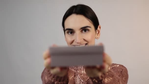 Jong brunette meisje bieden geschenken aan camera en glimlachen — Stockvideo