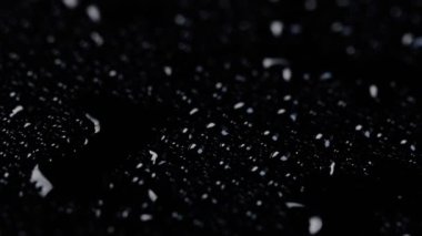 Siyah bir zemin üzerinde su damlacıkları kıvrımlı dokulu arka plan