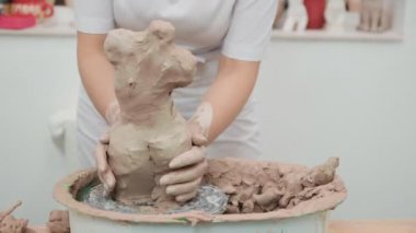 Elleriyle kille çalışan bir kadın. Çömlek atölyesi. Master sınıfı ve eğitim.