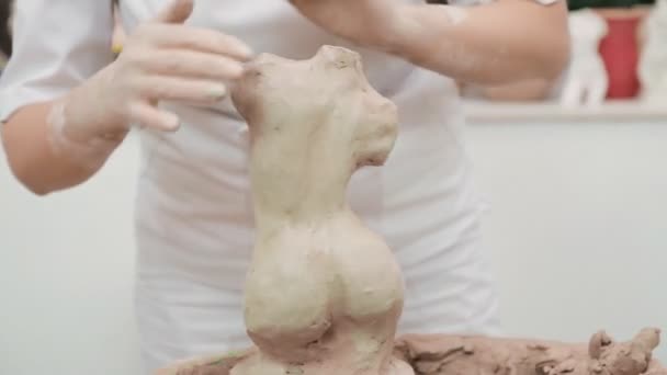 Vue rapprochée des mains des femmes travaillant sur le torse humain à partir d'argile de poterie. Sculpteur créant la sculpture dans l'atelier d'artiste. Concept d'œuvres d'art artisanales et de créativité. — Video