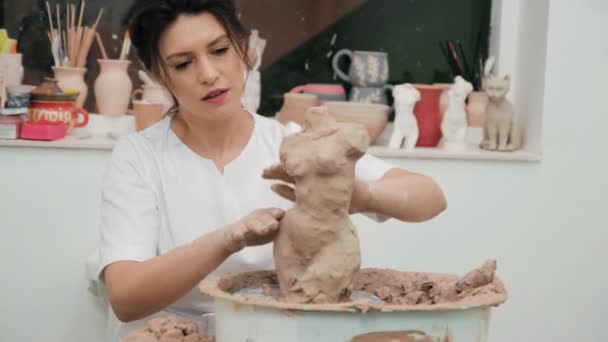 Girl sculptor artist creating a bust sculpture with clay. Sculptor at work. — Stock Video