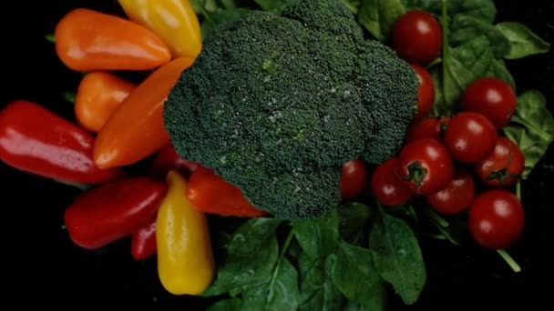 Högst upp. Färska gröna broccoli körsbärstomater, spenat, paprika roterar på en svart bakgrund. Shopping, hälsosam kost koncept. — Stockvideo