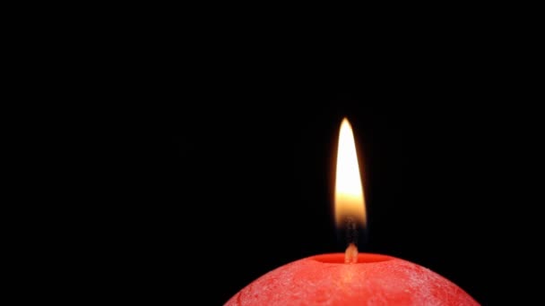 Burning red candle close up swirls on a black background — Stock Video