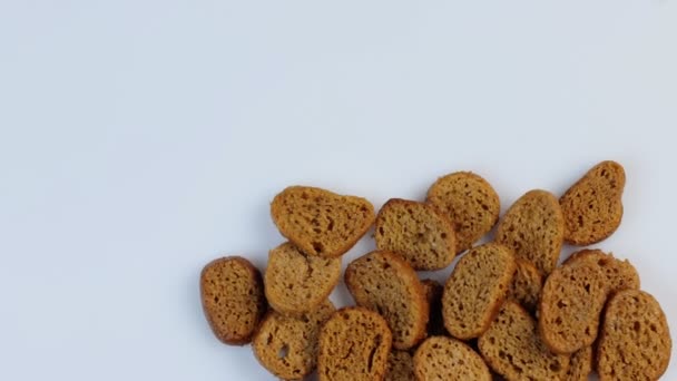 Kotouče tmavého pšeničného chleba se točí v kruhu na bílém pozadí. Koncept zdravých bezlepkových potravin — Stock video