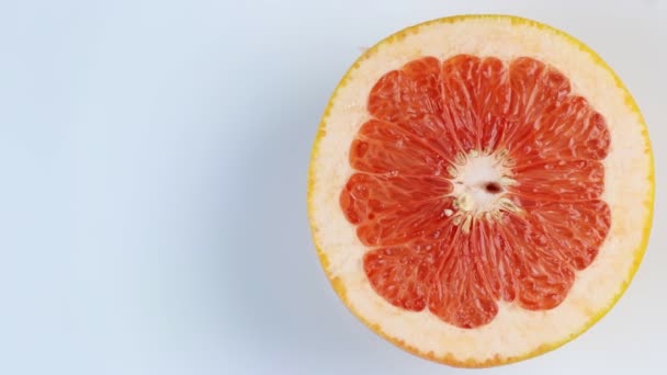 Půlka grapefruitu se otáčí, zblízka. Prostor pro text. Koncept zdravého životního stylu. — Stock video