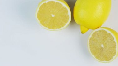 Beyaz arka planda taze limonları döndürmek