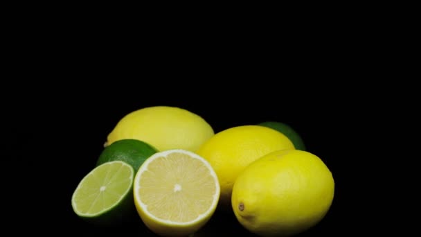 Świeże cytryny i limonki obracające się w kole, czarne tło i miejsce na tekst. — Wideo stockowe