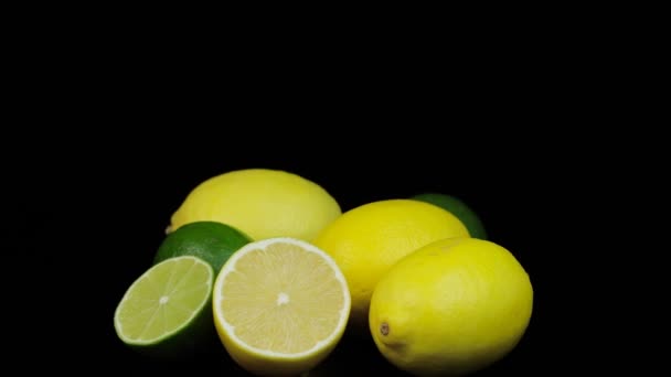 Limones y limas frescos girando en círculo, fondo negro y espacio para texto. — Vídeos de Stock