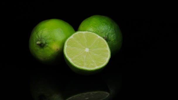 Limes frais tournant dans un cercle, fond noir, et l'espace pour le texte. Réflexion. — Video