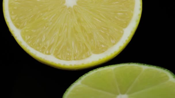 Çember şeklinde dönen limon ve limonları, siyah arkaplan ve yazı için alanı yarıya böl. Kapat. — Stok video