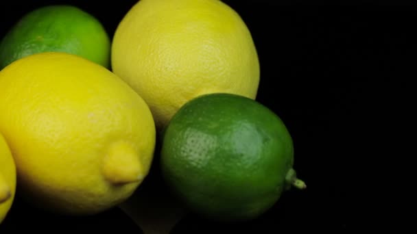 Limoni e lime freschi che ruotano in cerchio, sfondo nero e spazio per il testo. — Video Stock