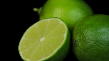  Daire şeklinde dönen taze limonlar, siyah arkaplan ve metin için boşluk. Yansıma.