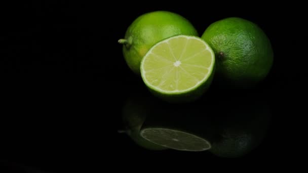 Limes frais tournant dans un cercle, fond noir, et l'espace pour le texte. Réflexion. — Video