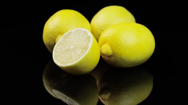 Limones frescos girando en círculo, fondo negro y espacio para el texto. Reflejos y aletas de agua. — Vídeos de Stock