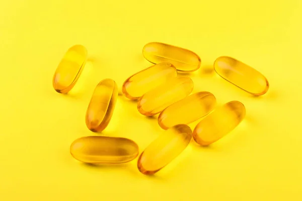 Vitamin D yellow pills on yellow background. space for text