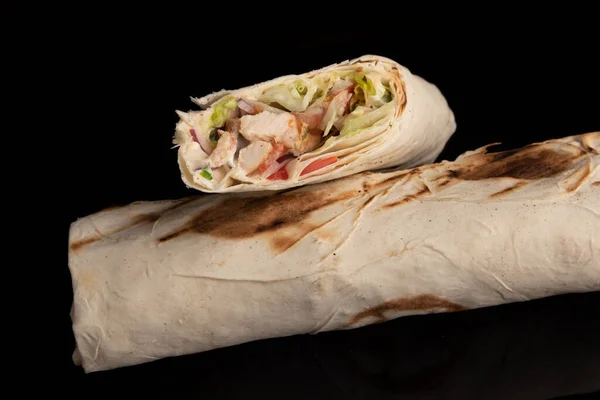 Classic shawarma kebab pita with chicken and vegetables and sauce on a black background. in section Royalty Free Stock Images