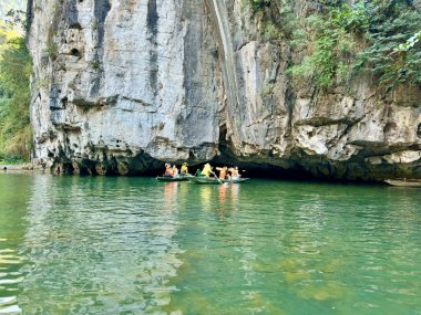 Tam Coc 'ta nehir ve karst dağlarını keşfeden geleneksel kürek çeken turistler - Bich Dong in the Trang An Peyzaj Kompleksi - Ninh Hai, Hoa Lu, Ninh Binh, Vietnam 17 Aralık 2025