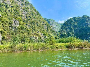 Tam Coc 'taki kireçtaşı dağları arasında kıvrılan Ngo Dong nehrinin panoramik görüntüsü. Tam Coc 'ta vahşi doğal güzellik - Bich Dong Trang An Peyzaj Kompleksi - Ninh Hai, Hoa Lu, Ninh Binh, Vietnam 17 Aralık 2025.