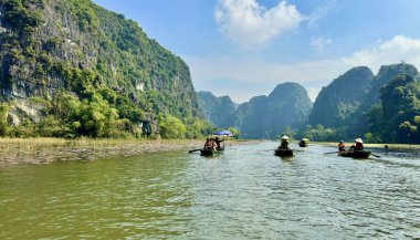 Turistler Ngo Dong Nehri 'nde tekne gezisinin tadını çıkarıyorlar. Tam Coc - Bich Dong in the Trang An Scenic Peyzaj Kompleksi - Ninh Hai, Hoa L