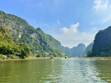 Dağlar boyunca kıvrılan yeşil nehrin panoramik manzarası. Basit el işi kayıklar, misafirleri, tam Coc-Bich Dong in the Trang An Scenic Peyzaj Kompleksi - Ninh Hai, Hoa Lu, Ninh Binh, Vietnam
