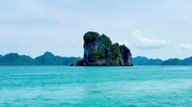 Bai Tu Long Bay Quang Ninh 'ın göbeğindeki eşsiz kireçtaşı adalarına yakın çekim. Dalgaların üzerinde hafifçe süzülerek yaradılışın başyapıtlarına hayran kalarak, zamanın dikey uçurumların ve yemyeşil bitki örtüsünün yanında durduğu yerde.