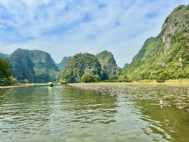 Ngo Dong Nehri 'nde canlı pembe nilüfer halılarını seyrederek el kürekli bir tekne gezisi yaşayın. Bu, ziyaretçilerin kendilerini doğaya daldırabildikleri en eşsiz turistik etkinliklerden biridir. Tam Coc - Bich Dong, Ninh Binh, Vietnam