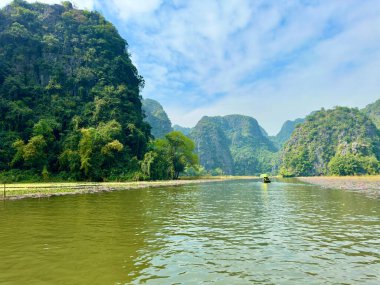 Ngo Dong Nehri, Ninh Binh 'deki görkemli ve yüksek kireçtaşı sıradağları arasında yavaşça esiyor. Sahne hala yeşil su ve her iki kıyıda uzanan nilüfer halı ile açılır. Tam Coc - Bich Dong, Ninh Binh, Vietnam