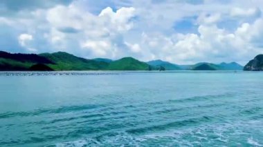 Birbirini takip eden iki yüksek hızlı feribot muhteşem kireçtaşı adalarından geçen dalgaları kesiyor. Ön tekneden bakıldığında, arka teknenin körfezin ortasında güçlü bir şekilde süzüldüğü görülüyor. Bai Tu Long Körfezi, Quang Ninh, Vietnam