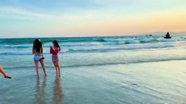 Tourists enthusiastically taking photos and checking in under the brilliant sunset at Van Chay beach. The video captures the panoramic view of the beach at the end of the day with many groups of young people and photographers capturing the best