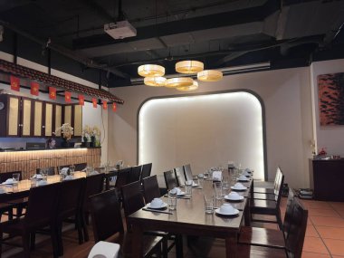 Hanoi 'de lüks bir restoranda profesyonel bir yemek masasının yakın plan görüntüsü. Masa temiz masa örtüleri, lüks çene farkındalığı ve yumuşak ışık altında cam örtülerle döşenmiştir. Hanoi, Vietnam 'da bir restoranda yakalandı.