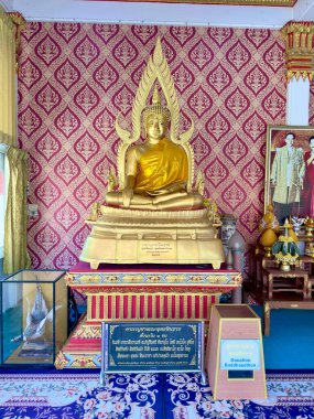 Pattaya, Tayland 'daki Büyük Buda Tapınağı' nın ana salonundaki parlak altın Buda heykelleri. Geleneksel desenli duvar kağıdı ve Tayland Kraliyet Ailesi portrelerinin yer aldığı kutsal bir ibadethane. Büyük Buda Tapınağı Pattaya, Tayland 29 Temmuz 202