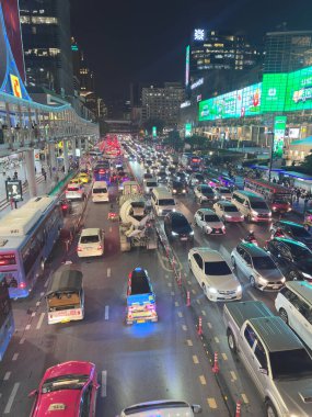 Gece Bangkok 'ta araçlar arasında beton karıştırıcı kamyonla yoğun trafik sıkışıklığı var. Büyük beyaz bir beton karıştırıcı kamyon, arabalar, taksiler ve tuk-tuk 'larla dolu şeritler boyunca yavaşça ilerliyor. 29 Temmuz 2025 'te Bangkok, Tayland' da yakalandı..