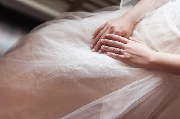 Bride hands on wedding gown — Stock Photo, Image