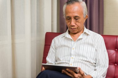 Asya kıdemli erkek tablet kullanma
