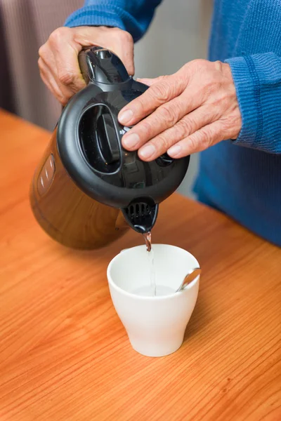 Heißes Wasser in Tasse gießen — Stockfoto