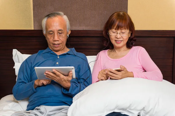 Asiático casal sênior com tecnologia móvel Imagens De Bancos De Imagens