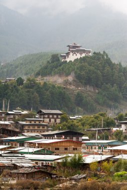 Jakar Dzong on mountain overlooking town clipart