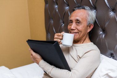 Asya kıdemli erkek ile sıcak içecek rahatlatıcı