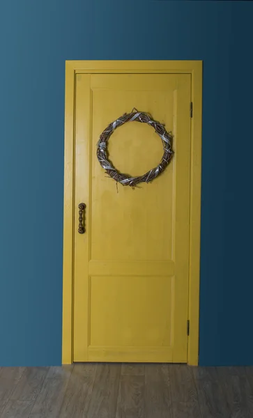 Porta amarela com uma grinalda de Natal — Fotografia de Stock