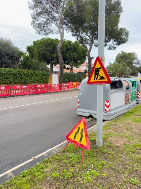 İnşaat için çitle çevrilmiş yol, trafik işaretleri yol çalışmalarını ve şeritlerin daraldığını gösteriyor. Kentsel altyapı ve trafik güvenliği.