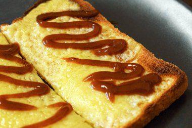 Kahverengi soslu tost üzerine peynir..