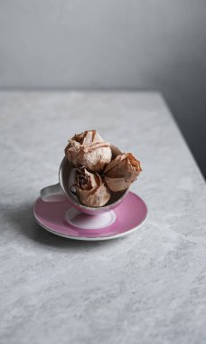 Hafif arka planda solmuş güller. Pembe bardakta kurumuş güller.