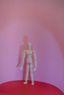 Ahşap adam kırmızı ve pembe arka planda duruyor. Yüksek kalite fotoğraf