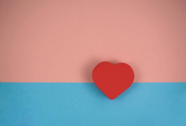 Mavi ve pembe arkaplanda bir kırmızı kalp