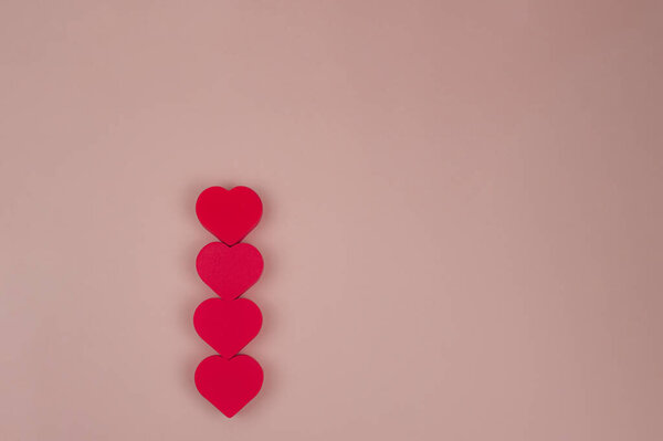 Четыре красных сердца на розовом фоне. Высокое качество фото