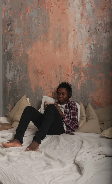 아프리카계 미국인 남자가 헤드폰을 침대에 전화를 있습니다 고품질 — 스톡 사진