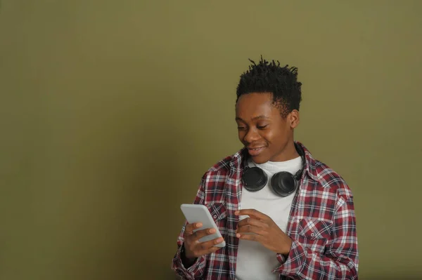 Ung afrikansk amerikan kille talar i telefon på en grön bakgrund — Stockfoto